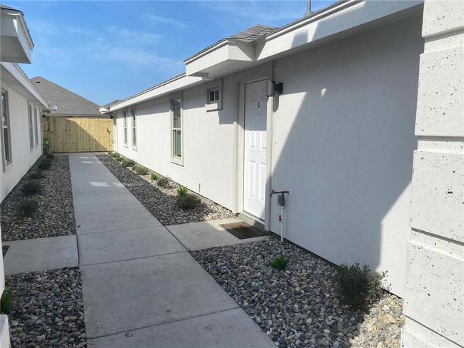 View of property exterior with stucco siding and fence | Image 6