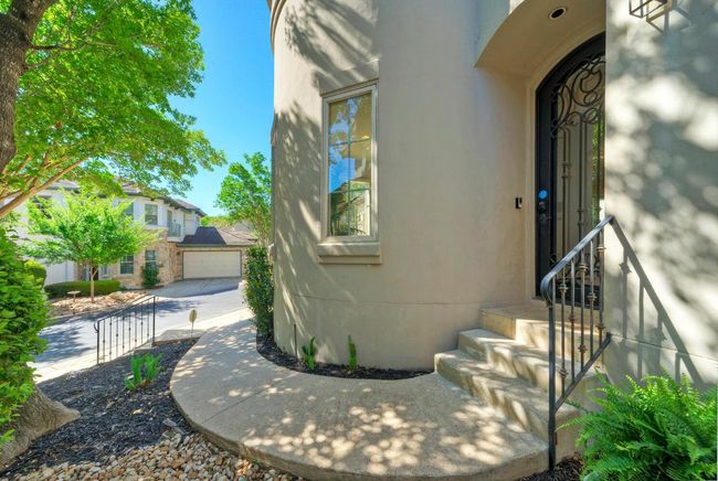 private walkway greeted by wrought iron door at the front entrance | Image 9