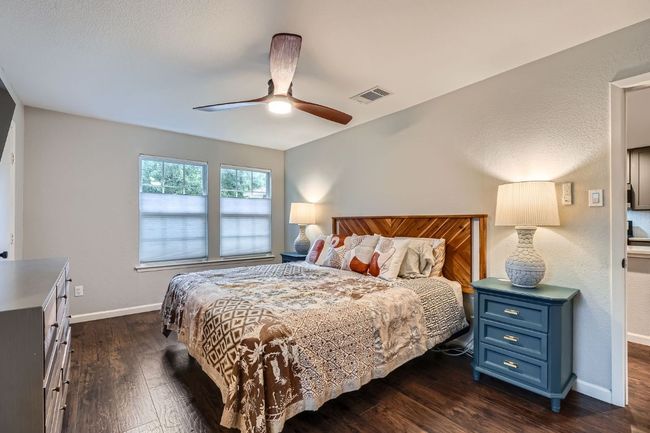 Bedroom with dark wood-style floors and ceiling fan | Image 15