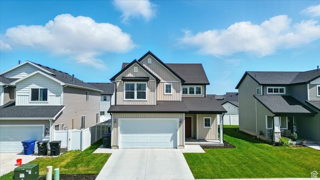 Craftsman house with board and batten siding, a garage, concrete driveway, and a residential view | Image 21