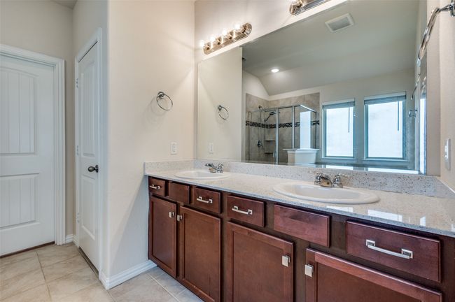 Primary bathroom with a stall shower, tile patterned floors and double vanity | Image 16