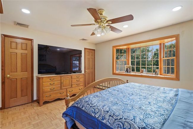 Bedroom with baseboard heating, light parquet flooring, and ceiling fan | Image 16