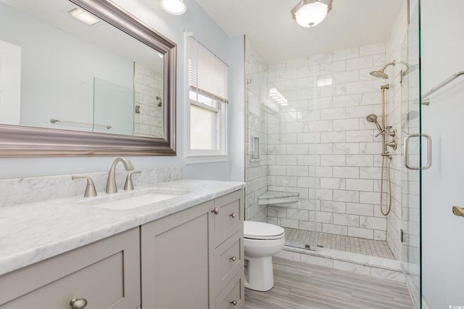 Full bath with wood finished floors, toilet, vanity, and a stall shower | Image 19