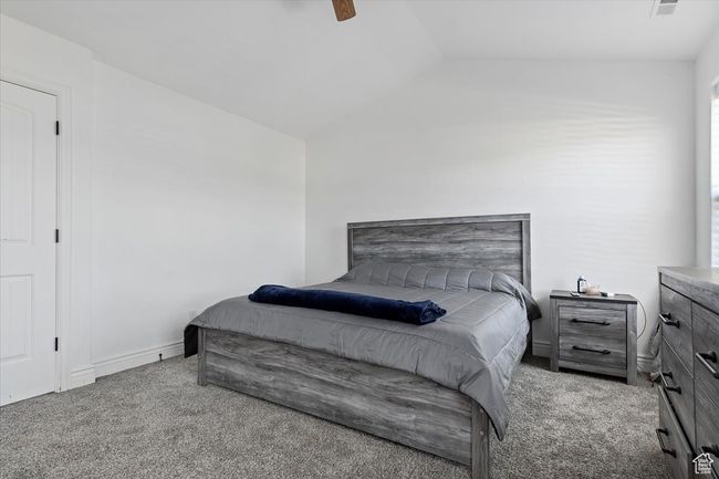 Carpeted bedroom featuring ceiling fan and lofted ceiling | Image 18