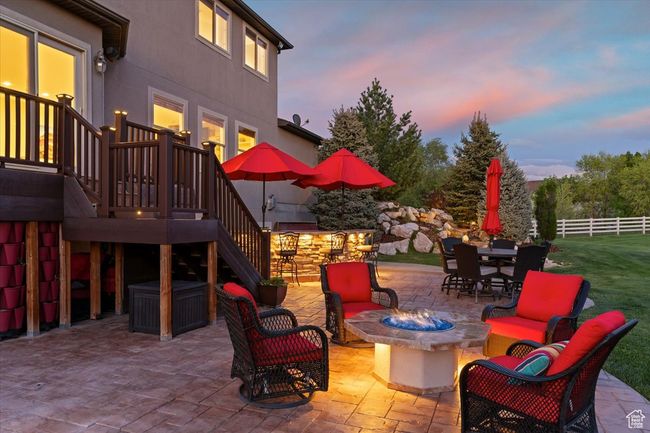 Patio terrace at dusk featuring an outdoor living space with a fire pit, fence, and stairway | Image 64