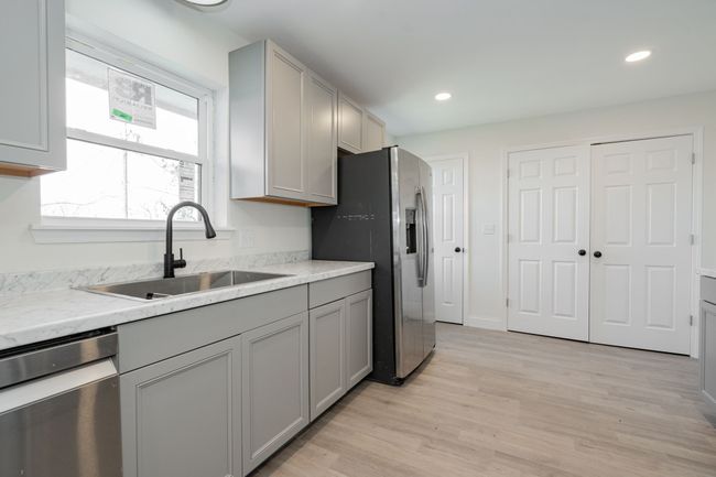 Kitchen featuring appliances with stainless steel finishes, gray cabinets, light wood finished floors, and recessed lighting | Image 9