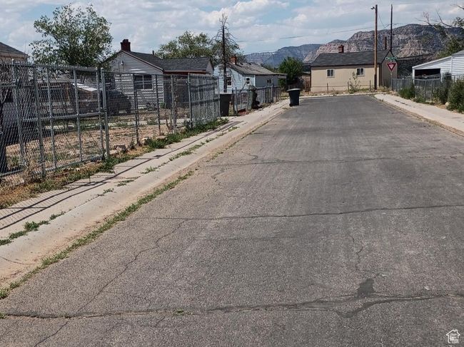 View of asphalt street featuring sidewalks and curbs | Image 60