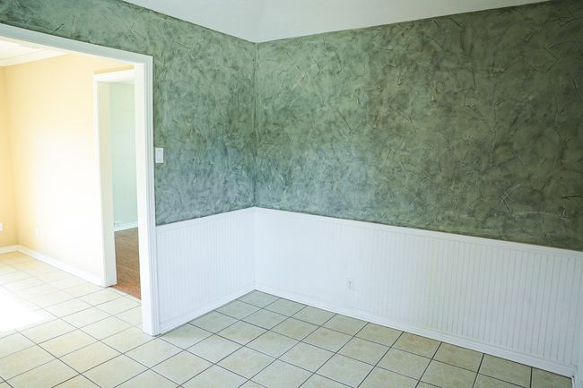 Unfurnished room with a wainscoted wall and light tile patterned flooring | Image 15