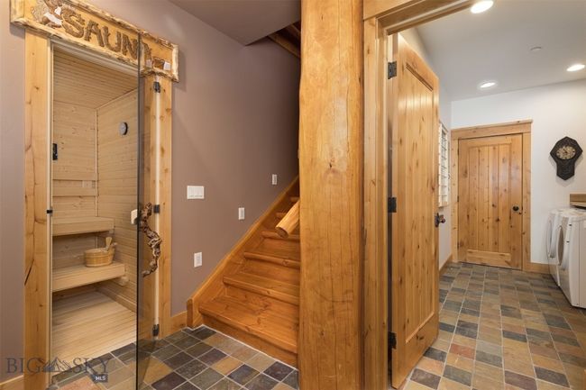 Entry level entryway to sauna, stairs to main level, and hallway to laundry and mechanical rooms. | Image 62