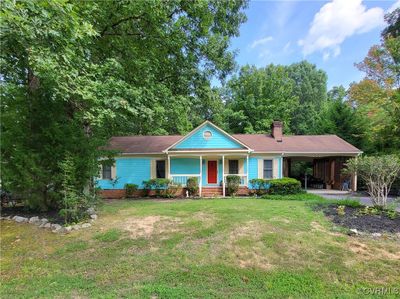 Single story home featuring a front yard and covered porch | Image 1