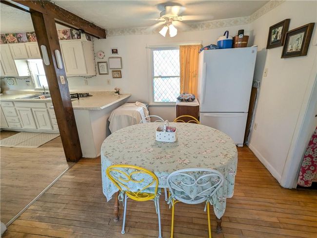 Dining room featuring a ceiling fan, beamed ceiling, and light wood-type flooring | Image 22