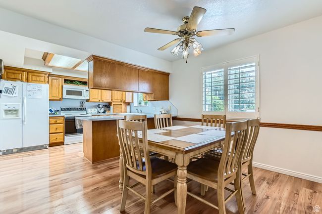 Dining room featuring light wood-style floors and a ceiling fan | Image 6