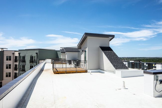 Rear view of property featuring a balcony and roof with shingles | Image 21