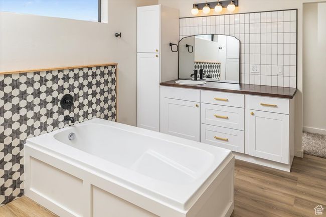 Bathroom featuring wood-type flooring, vanity, and a bathtub | Image 21