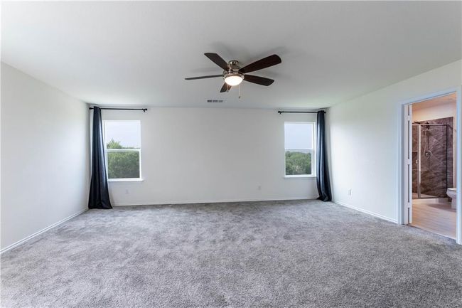 Carpeted empty room featuring healthy amount of natural light and ceiling fan | Image 26