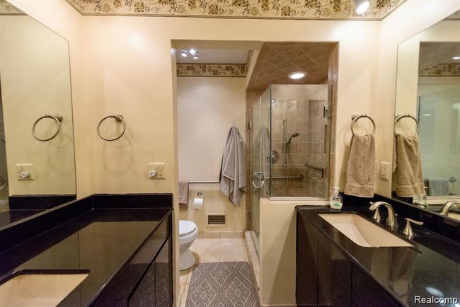 Bathroom with a stall shower, two vanities, and light tile patterned floors | Image 24