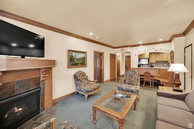 Living area featuring baseboards, ornamental molding, recessed lighting, and a tiled fireplace | Image 14