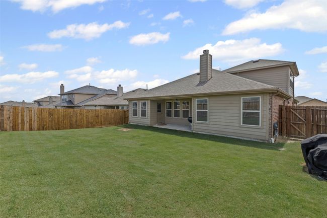 Back of house with a fenced backyard, a patio, a chimney, and a shingled roof | Image 29