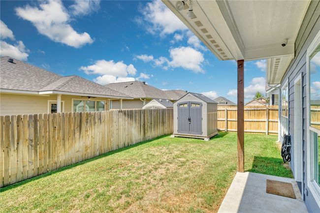 Fenced backyard featuring a shed and ceiling fan | Image 31