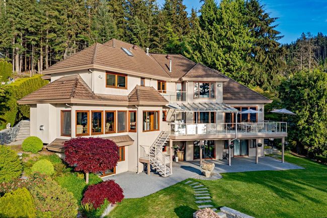 Back of property with a patio area, a deck, stucco siding, stairway, and a sunroom | Image 8