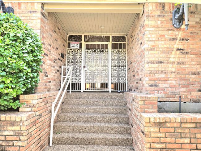 View of exterior entry featuring a porch and brick siding | Image 19