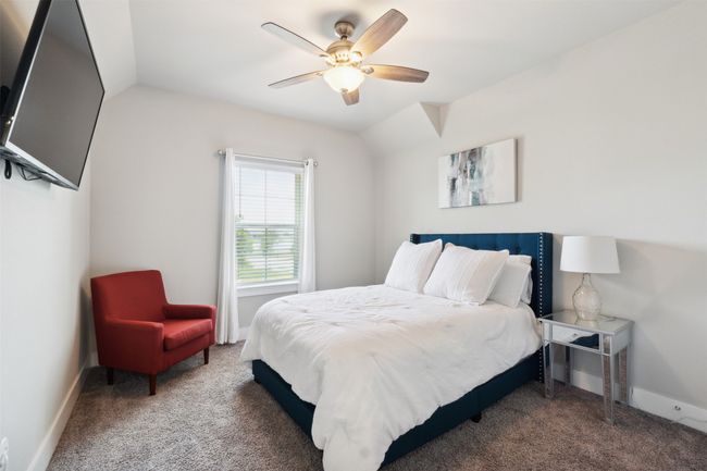 Carpeted bedroom featuring a ceiling fan and lofted ceiling | Image 26