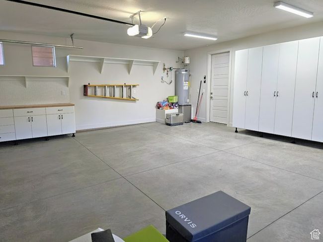 Garage with baseboards, electric water heater, and a garage door opener | Image 33