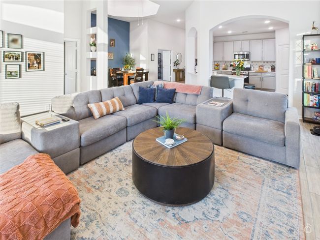 Living area featuring arched walkways, wood finished floors, and recessed lighting | Image 17