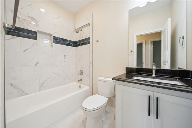 Full bathroom featuring vanity, tiled shower / bath combo, and toilet | Image 15