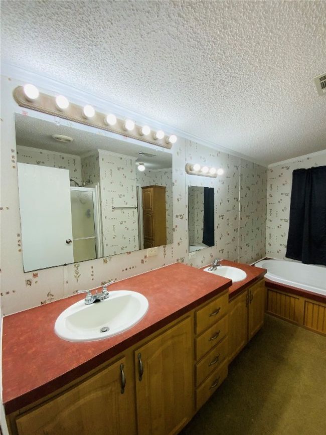 Full bathroom featuring wallpapered walls, a textured ceiling, and a sink | Image 20