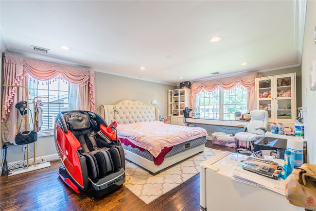 Bedroom with crown molding, wood finished floors, recessed lighting, and baseboards | Image 13