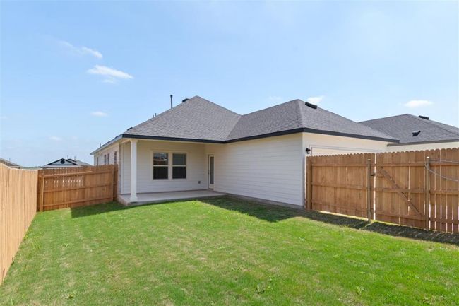 Rear view of property featuring a fenced backyard, a lawn, and roof with shingles | Image 31