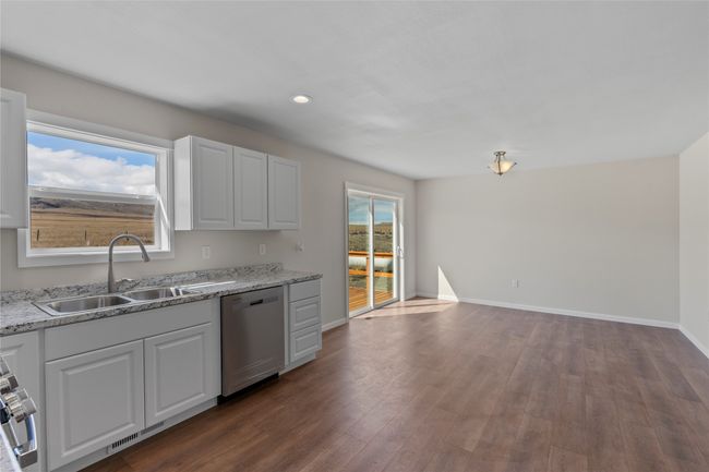 Kitchen with baseboards, dark wood finished floors, a sink, visible vents, and dishwasher | Image 38