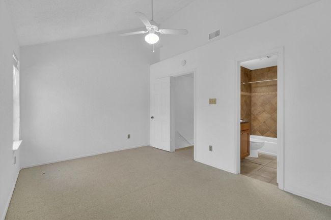 Unfurnished bedroom featuring connected bathroom, visible vents, ceiling fan, and light carpet | Image 22