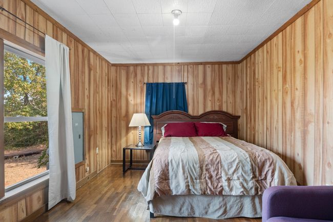 Bedroom with dark hardwood / wood-style flooring and wooden walls | Image 20