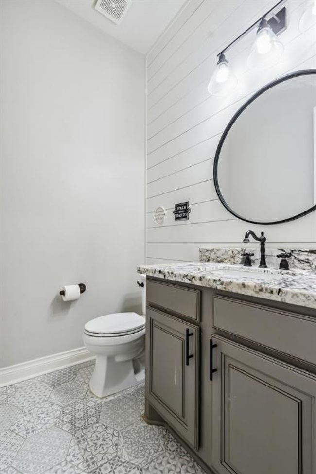 Half bath features shiplap wall and decorative tile floor. | Image 23