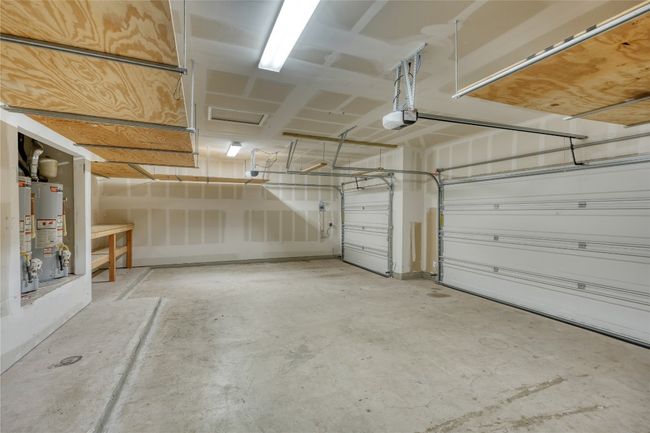 Garage featuring water heater and a garage door opener | Image 17