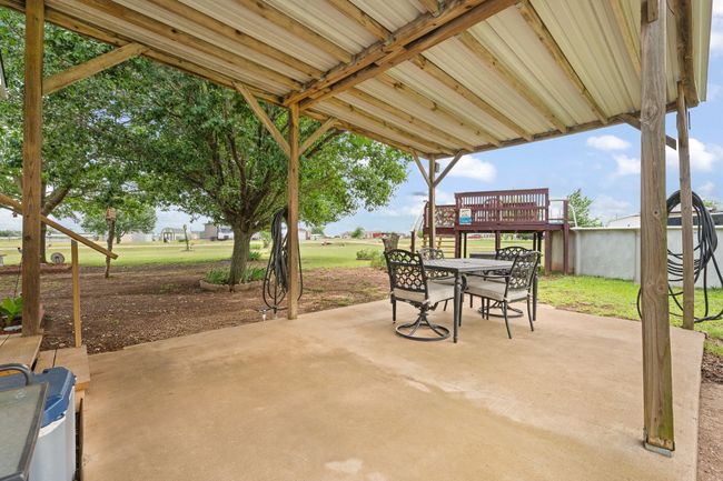 View of patio with outdoor dining space, a wooden deck, and stairway to sparkling pool | Image 30