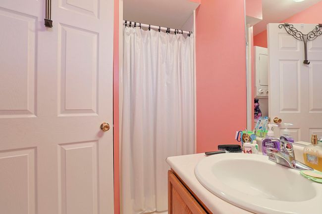 Bathroom featuring curtained shower and vanity | Image 9