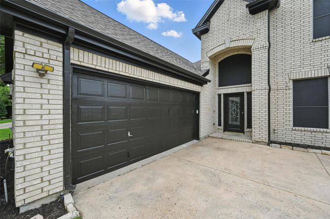 Property entrance featuring brick siding, driveway, and roof with shingles | Image 5