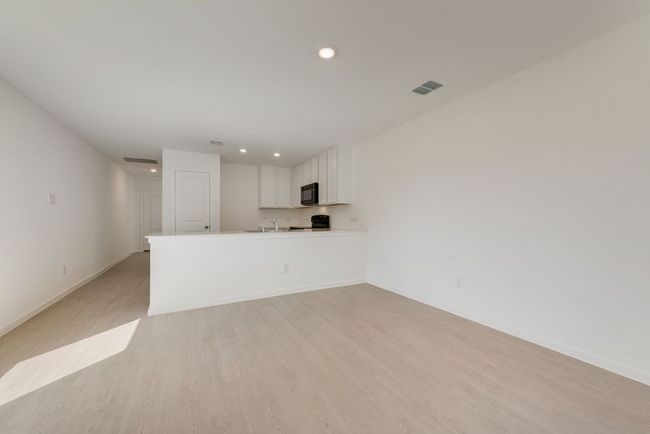 Unfurnished living room featuring light wood-style flooring and recessed lighting | Image 5