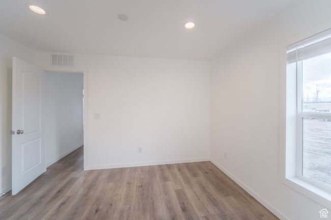 Spare room featuring light wood finished floors, visible vents, recessed lighting, and baseboards | Image 11