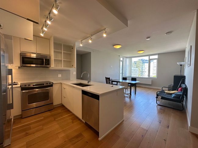 Kitchen with appliances with stainless steel finishes, a sink, open shelves, light countertops, and a peninsula | Image 21