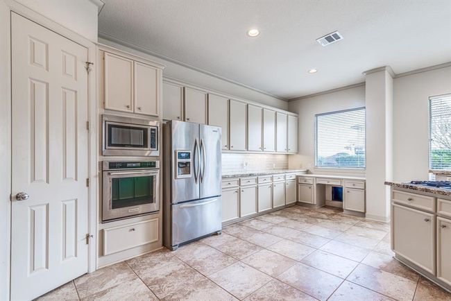 The kitchen stuns With so much space. 42" cabinets for abundance of storage. Lots of counter top area with updated gorgeous granite. Convenient desk area complete with doggy door! | Image 17