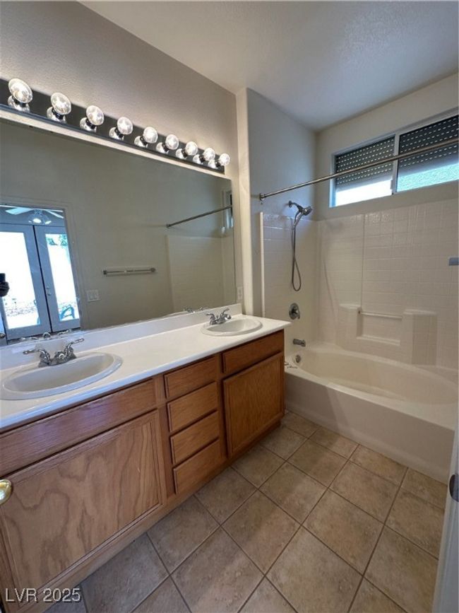 Full bath featuring healthy amount of natural light, tile patterned flooring, shower combination, and double vanity | Image 19