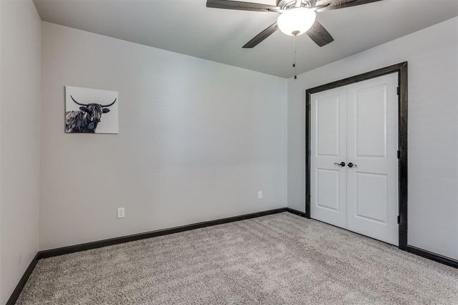 Unfurnished bedroom featuring ceiling fan, baseboards, a closet, and carpet | Image 14