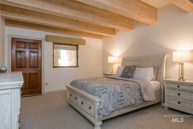 Bedroom featuring light carpet and beam ceiling | Image 12