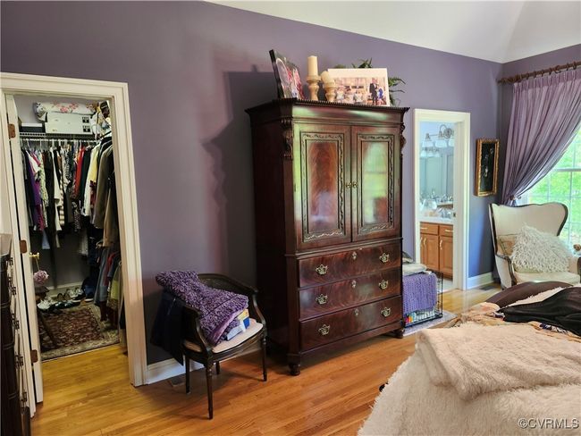 Primary Bedroom with a closet, a spacious closet, lofted ceiling, and light wood-type flooring | Image 27