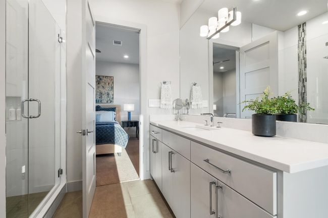 Bathroom with ensuite bathroom, vanity, tile patterned flooring, visible vents, and a stall shower | Image 26