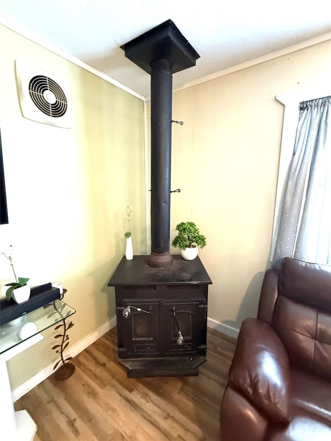 Detailed view of a wood stove and wood finished floors | Image 11